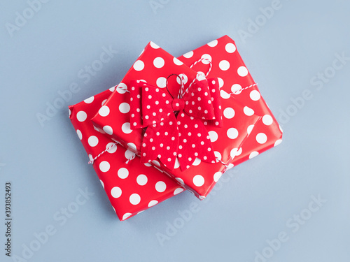 Vintage style gifts stack wrapped in polka dot paper with bows on blue background. Christmas, Valentines day