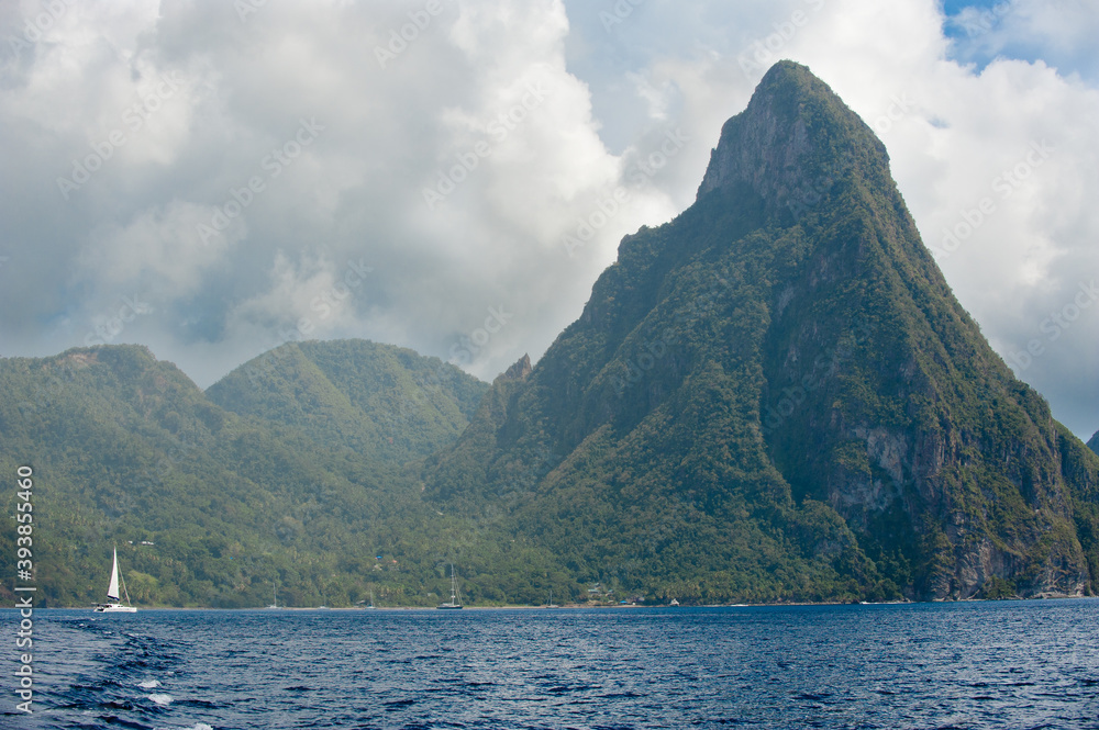 View from sea of one of the two pitons on Caribbean Island of St Lucia.Sailing boat visible