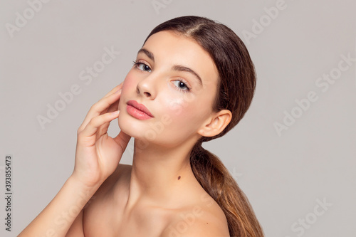 health and beauty concept - Beautiful Young Woman with Clean Fresh Skin touch own face . Facial treatment . Cosmetology , beauty and spa .