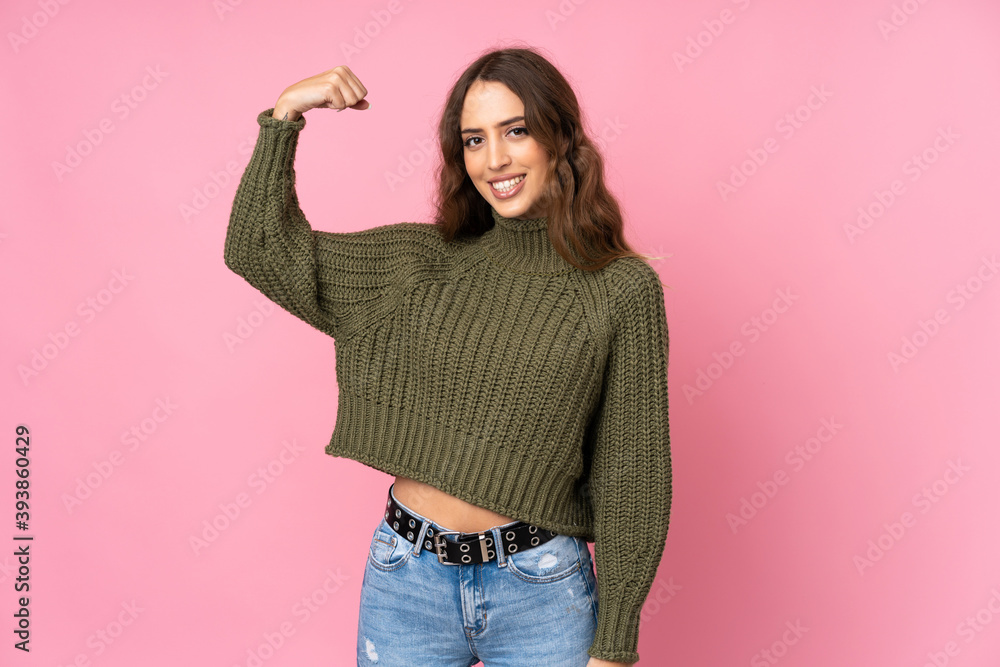 Young woman over isolated pink background doing strong gesture Young woman over isolated pink background doing strong gesture