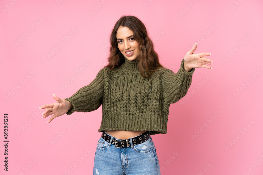 Young woman over isolated pink background presenting and inviting to come with hand Young woman over isolated pink background presenting and inviting to come with hand