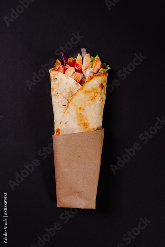 Chicken shawarma on a dark background. Shawarma with chicken in pita bread