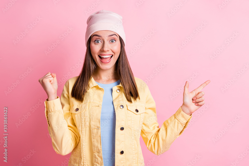 Photo of happy amazed brown haired woman raise fist point empty space subscribe isolated on pink color background Photo of happy amazed brown haired woman raise fist point empty space subscribe isolated on pink color background