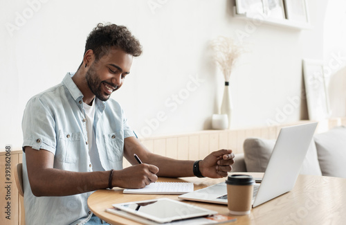 Young handsome man using laptop at home, Businessman or student working online on computer indoors, Freelance, online marketing, distance education, e-learning, home work and lockdown concept