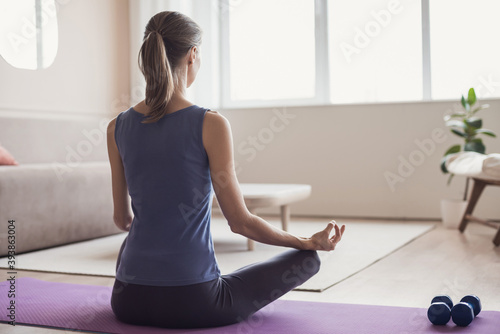 Woman meditate at home, Girl training and practicing yoga indoors, Harmony, balance, meditation, relaxation, healthy lifestyle, lockdown concept