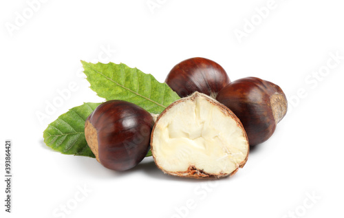 Fresh sweet edible chestnuts with green leaves on white background