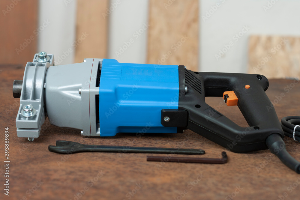 Wrench and mixing drill for mixing of mortar, paint , plaster and powder on old rusty metal sheet. Wrench and mixing drill for mixing of mortar, paint , plaster and powder on old rusty metal sheet.