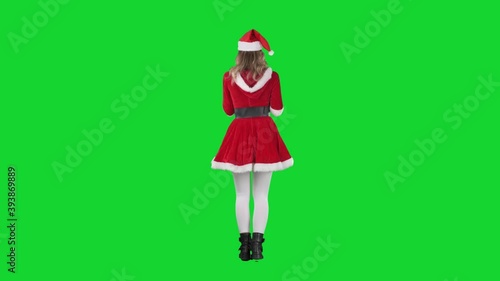 Back view of dancing Santa Claus girl in costume carefree and joyful. Full body length on green screen. 