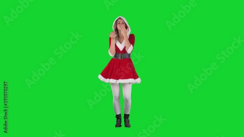 Flirty attractive Santa Claus girl sending and blowing air kisses at camera. Full body length on green screen. 