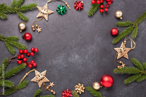 Christmas background with fir tree and decoration on dark stone background. Top view Copy space