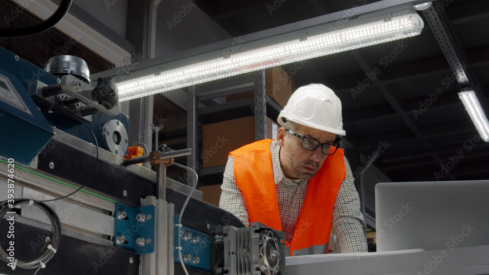 Industrial engineer with laptop working in manufacturing plant Industrial engineer with laptop working in manufacturing plant