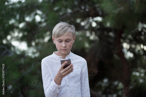 Pensive cute teenager talking on phone, outdoor.