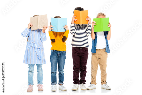 Kids holding colorful books near faces on white background