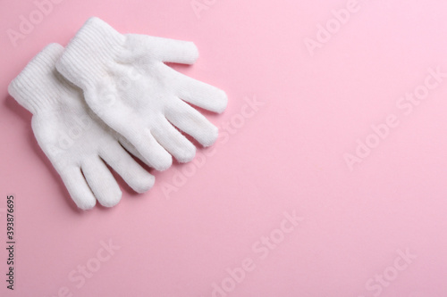 Pair of stylish woolen gloves on pink background, flat lay. Space for text