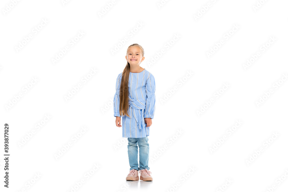 Cheerful kid smiling while standing on white background Cheerful kid smiling while standing on white background