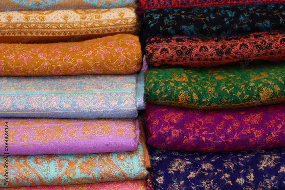 Stack of colourful textile material on display in a market Stack of colourful textile material on display in a market