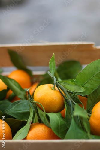 Wooden crate with fresh tangerines. Selective focus.