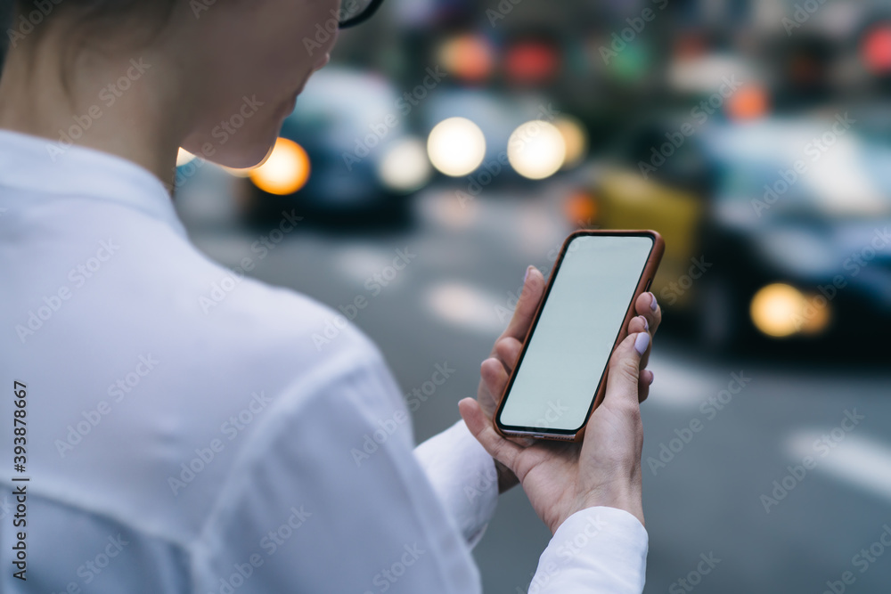 Crop anonymous woman checking smartphone while standing on roadside Crop anonymous woman checking smartphone while standing on roadside