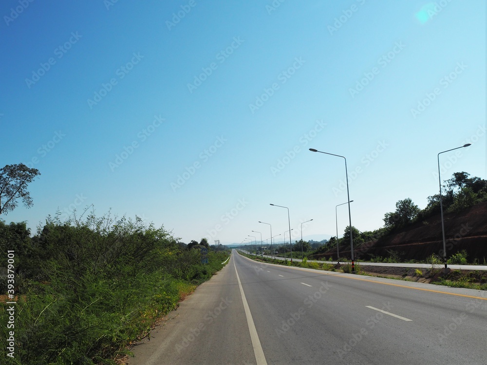 Fototapeta premium The entry road go to the mountains with blue sky