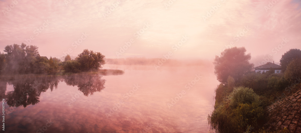 Pink sky, mist, fog over the river. Dreamy summer morning white clouds, silhouettes of trees