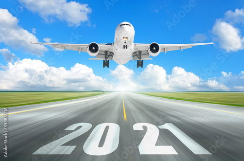 The plane flies over the runway with the inscription 2021. The concept of meeting the new year.