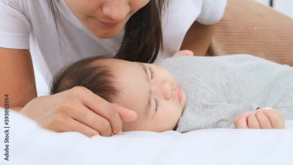 Newborn baby girl 7 months is sleeping and mother kiss her cheeks of baby with love,slow motion shot. Newborn baby girl 7 months is sleeping and mother kiss her cheeks of baby with love,slow motion shot.