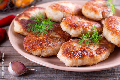 Delicious fish cutlets with dill closeup in a plate on the table. Horizontal