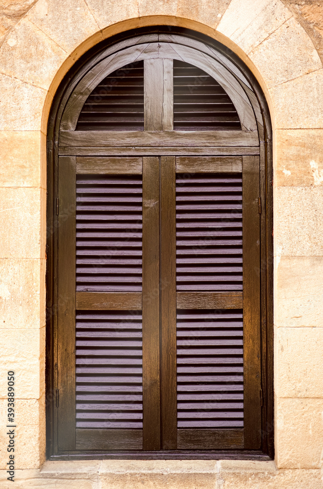 Fototapeta premium Arched window with closed shutters