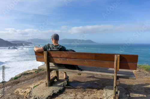 man relaxing and enjoying the vie at the cliffs of Loiba in Galicia photo