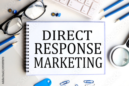 Tela direct response marketing, text on white paper on a light background near glasse