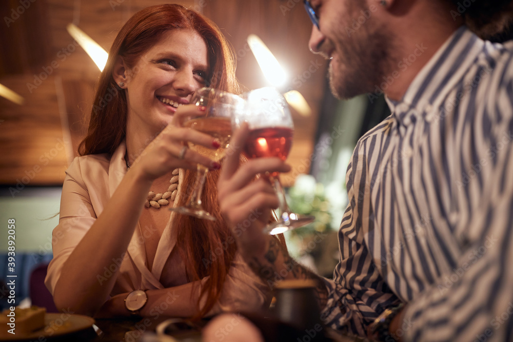 A young couple in love toasting at anniversary celebration at a restaurant. Together, anniversary, celebration A young couple in love toasting at anniversary celebration at a restaurant. Together, anniversary, celebration