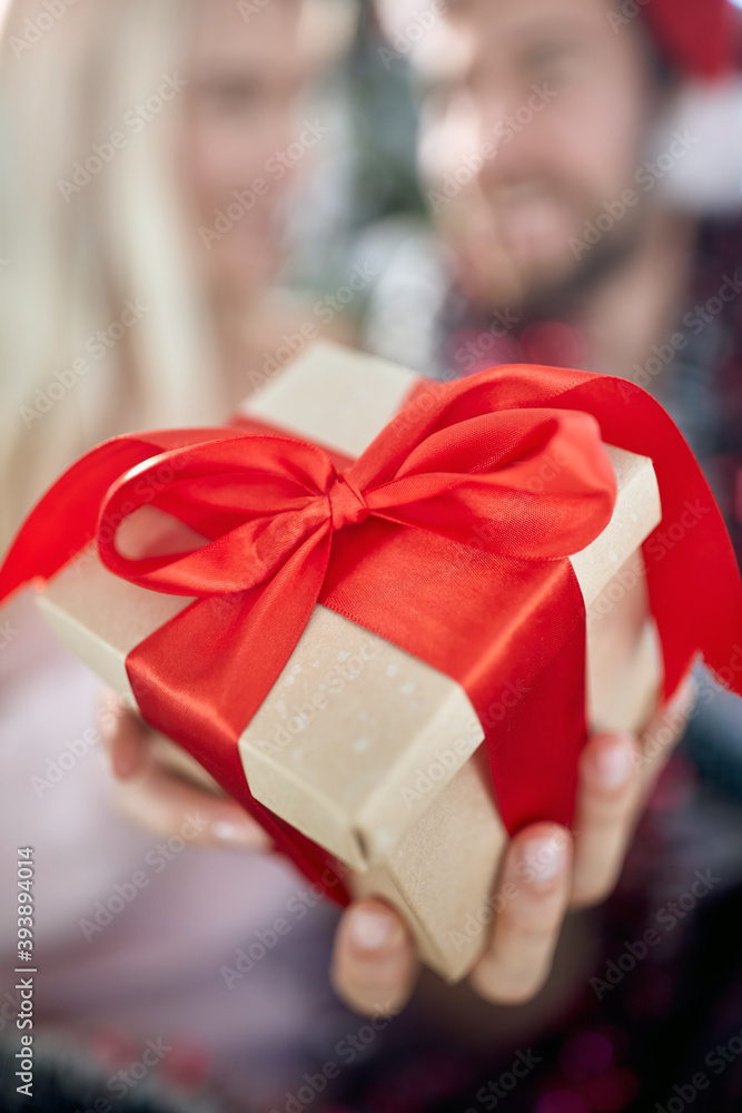 A lovely couple at home showing a Xmas present. Christmas, relationship, love, together A lovely couple at home showing a Xmas present. Christmas, relationship, love, together