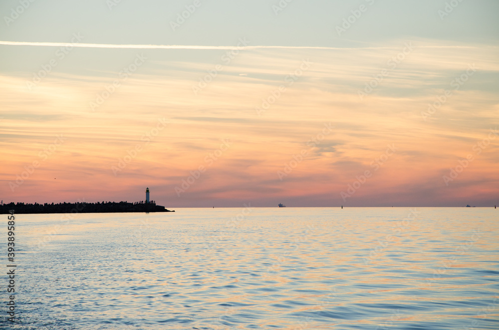 Naklejka premium sunset lighthouse sea