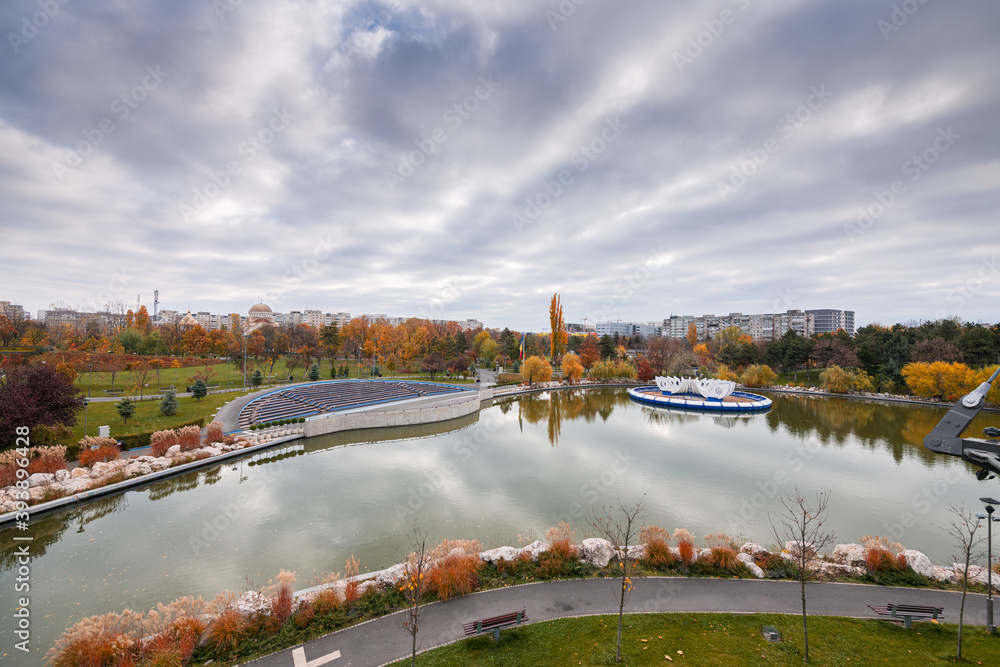 Fototapeta premium Autumn landscape of Drumul Taberei Park in Bucharest city capital of Romania with cloudy sky and great fall colors
