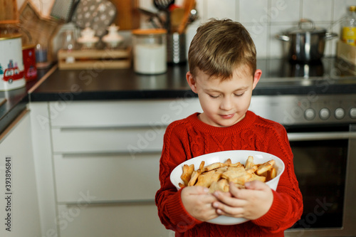 little boy holding a plate of cookies in the form of stars. Christmas cookies.