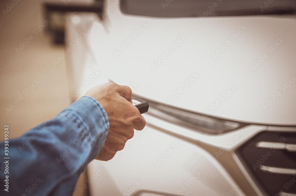 Obraz premium Remote control of the white car in the hand of the man was locking the car.