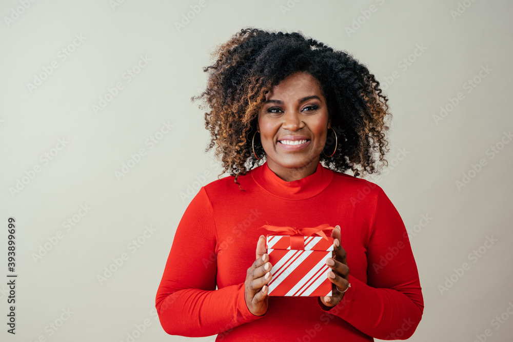 Portrait of a happy mid woman holding red Christmas gift box Portrait of a happy mid woman holding red Christmas gift box