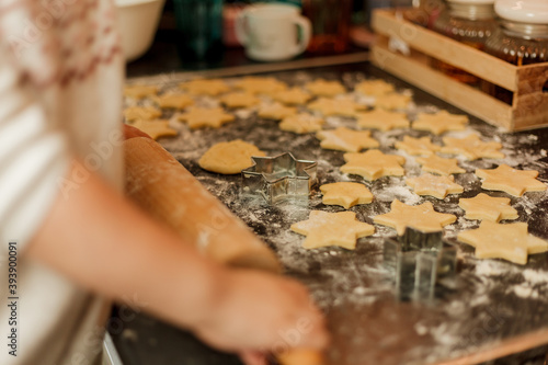 little girl bakes cookies in the form of stars. Christmas cookies.
