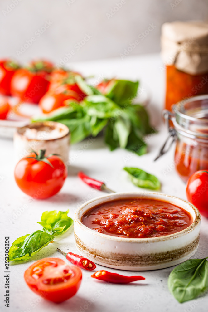 Bowl of italian tomato sauce with basil and fresh tomatoes on white background Bowl of italian tomato sauce with basil and fresh tomatoes on white background
