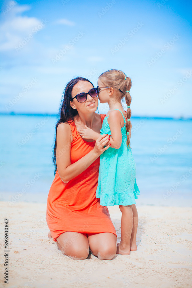 Beautiful mother and daughter at the beach enjoying summer vacation Beautiful mother and daughter at the beach enjoying summer vacation
