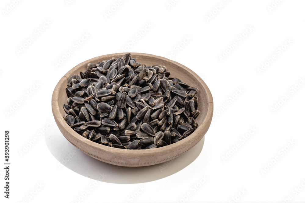 Sunflower seeds in a plate on a white background Sunflower seeds in a plate on a white background