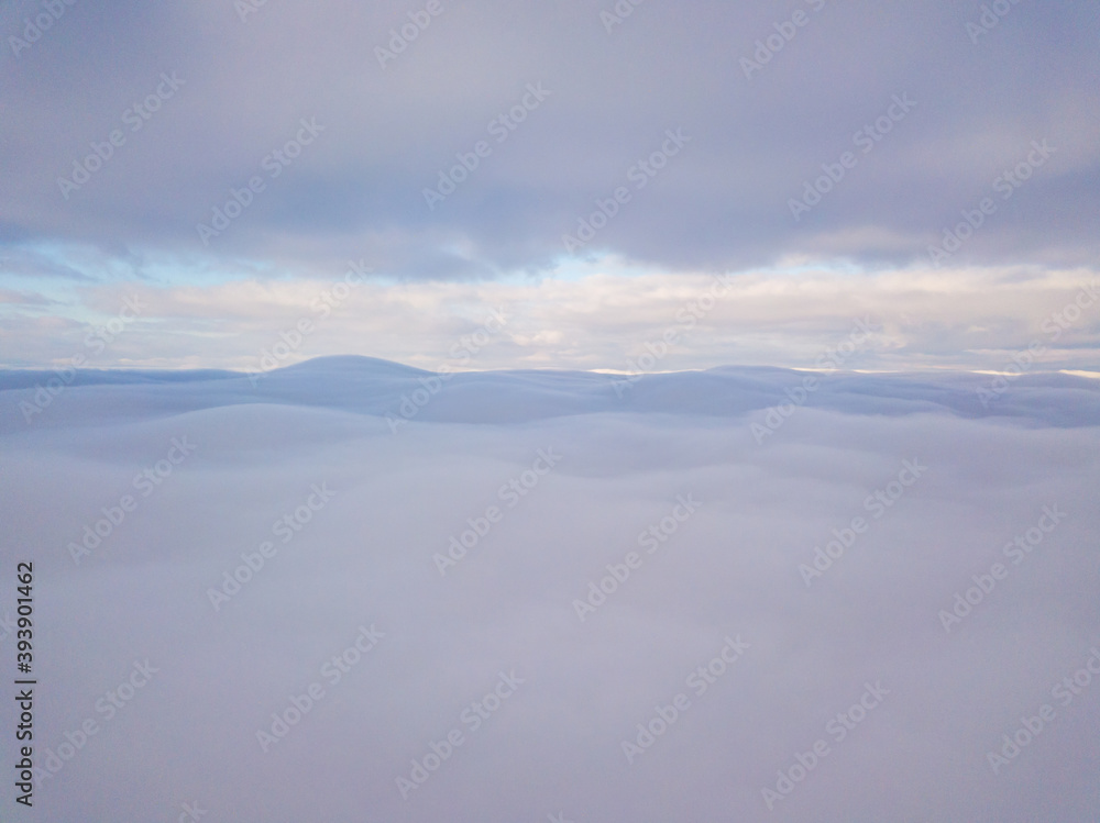 High aerial flight between fog and clouds.