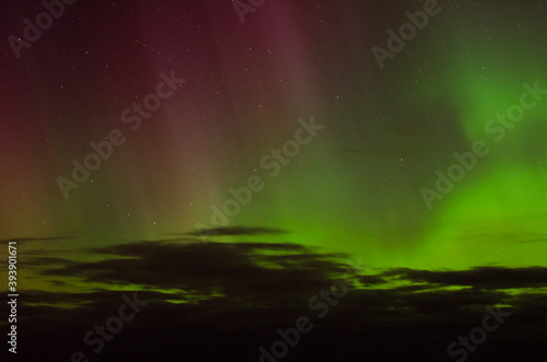 green and violet aurora borealis by the sea 