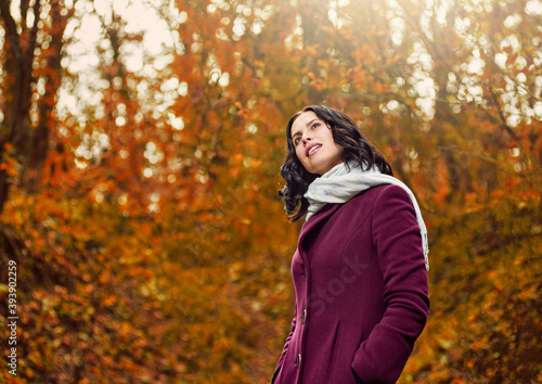 Portrait of happy young pretty woman walking in autumn park