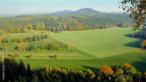 Herbstliche Aussicht vom Pfaffenstein auf Wiesen und Wald des Elbsandsteingebirge an sonnigem Tag