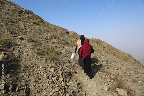  Yemeni women bring their food and drink needs through rugged mountain roads because of  Al-Houthi militia siege of the villages of Jabal Habashi District in the in Taiz City photo