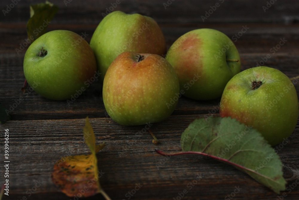 Green apples and autumn leaves on the table Green apples and autumn leaves on the table