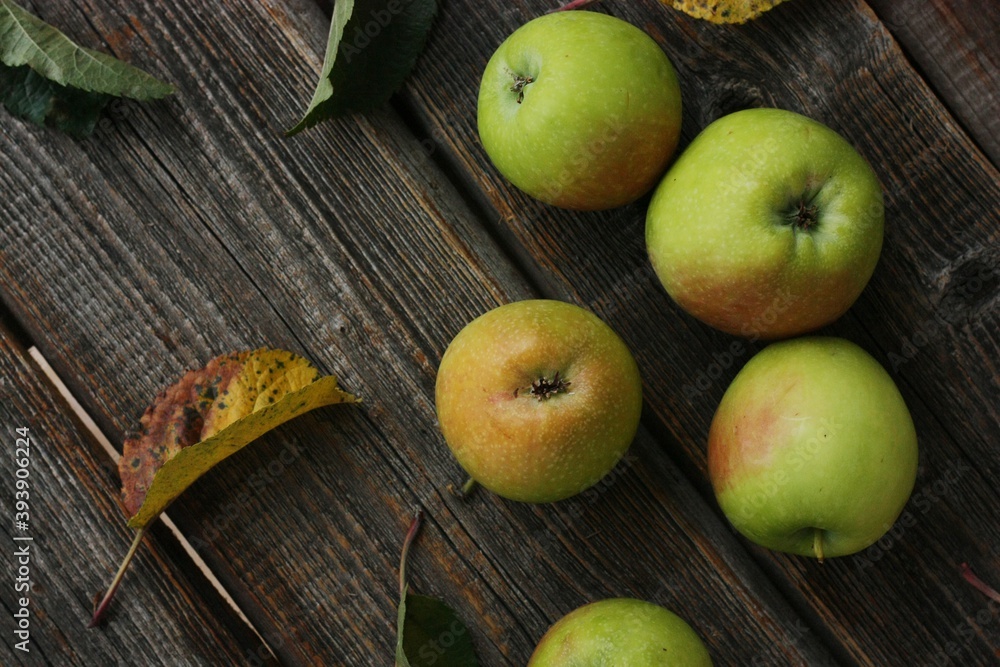 Green apples and autumn leaves on the table Green apples and autumn leaves on the table