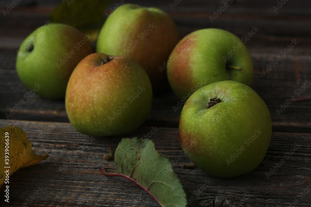 Green apples and autumn leaves on the table Green apples and autumn leaves on the table