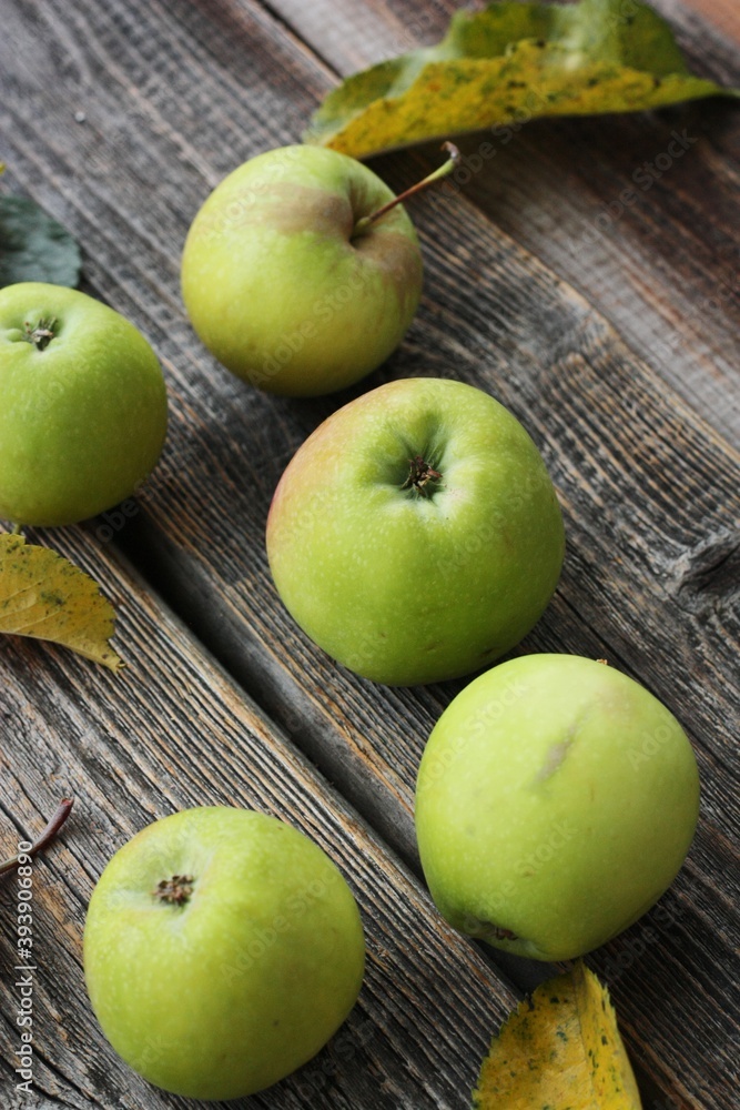 Green apples and autumn leaves on the table Green apples and autumn leaves on the table